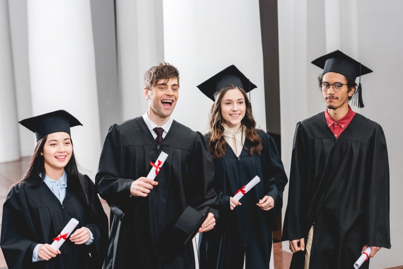 smiling group on students in graduation gowns hold 2022 11 03 09 50 06 utc Custom 1